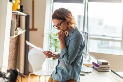 Home seller reviewing paperwork and considering important decisions before listing their house